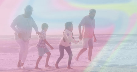 Walking senior grandparents and grandchildren along sandy shoreline, with calm ocean and clear sky. Family, multigenerational, outdoor, natural, leisure, tranquility, coastlineの写真素材