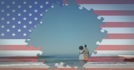 Walking couple strolling along sandy shoreline with gentle ocean waves, with jigsaw puzzle flag. Patio, outdoor, vibrant, unity, exploration, serenity, leisureの写真素材