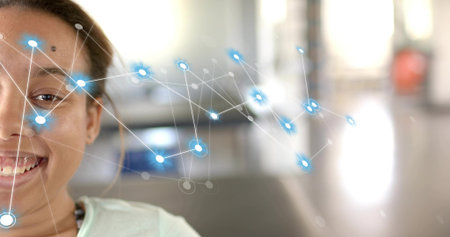 Smiling woman wearing light top and small necklace in bright lobby blue network overlay, copy space. Portrait, closeup, augmented, grid, glow, interior, officeの写真素材