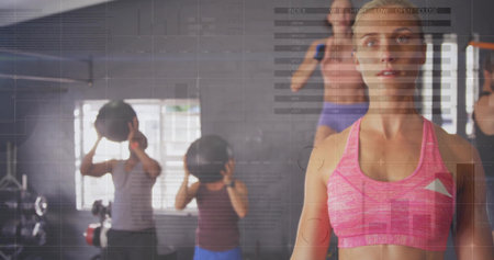 Trainer in sportswear guiding group using medicine balls in gym, with data overlays, copy space. Training, strength, wellness, coaching, vitality, motion, healthの写真素材