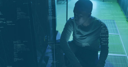 Crouching technician inspecting racks in server room, with blinking LEDs and code overlay, copy space. Technology, infrastructure, cybersecurity, industrial, digital, professional, innovationの写真素材