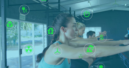 Reaching woman in tank top, leggings stretching barre in fitness studio with sustainability icons. Fitness, wellness, strength, flexibility, eco-friendly, conservation, modernの写真素材