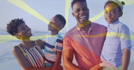 Smiling family of four holding children on beach by gentle waves, showcasing patterned headband. Family, togetherness, connection, outdoor, leisure, happiness, lifestyleの写真素材