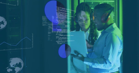 Collaborating IT professionals sharing code in server room with laptop, headset and data overlays. Technology, innovation, data visualization, teamwork, cybersecurity, modern designの写真素材
