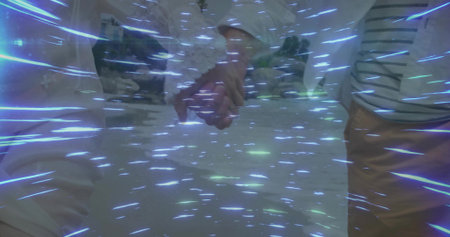Holding couple hands on sandy desert plain under swirling blue light streaks, wedding ring visible....