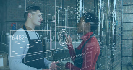 Discussing brewing data interface in black aprons amid steel tanks and piping in brewery facility. Craftsmanship, industrial, innovation, teamwork, technology, manufacturing, precisionの写真素材