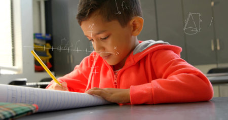 Writing boy wearing red hoodie solving math equations in classroom, with notebook and yellow pencil. Education, learning, students, classroom, creativity, concentration, studyの写真素材