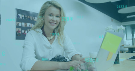 Sitting female photographer typing on laptop at modern workspace, with DSLR camera and sticky notes. Co-working, creativity, modern, collaboration, profession, innovation, minimalismの写真素材