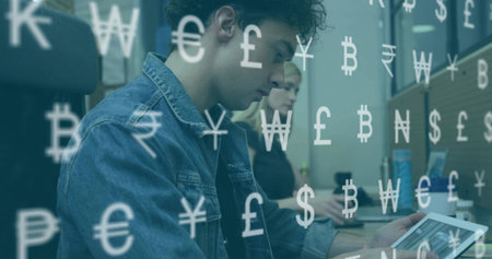 Using keyboard adult male holding tablet in office, with monitors, mug, can and currency overlays. Professional, collaboration, technology, finance, business, modern, teamworkの写真素材