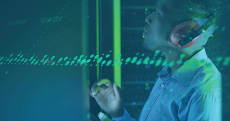 Man wearing shirt manipulating data streams in datacenter, server racks, red headphones, copy space....