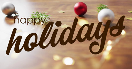 Image of happy holidays text over christmas decorations on wooden background. Christmas, tradition and celebration concept digitally generated image.の写真素材