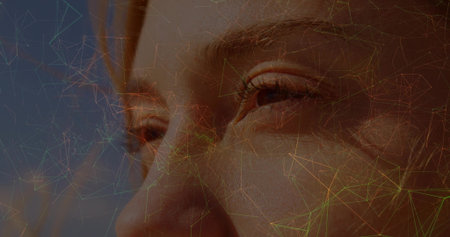 Showcasing adult woman's face and eyes in abstract backdrop, with translucent network overlay. Portrait, technology, futuristic, digital, innovation, cybersecurity, holographicの写真素材