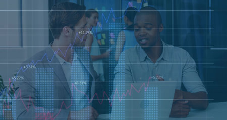 Collaborating business professionals analyzing laptop in office, with sticky board and data overlay. Teamwork, brainstorming, strategy, data analysis, office environment, corporate, innovationの写真素材