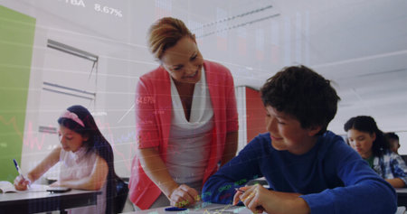 Leaning female teacher guiding boy writing assignment at desk in classroom with notebook and pencil. Education, learning, classroom, tutoring, mentorship, study, academicの写真素材