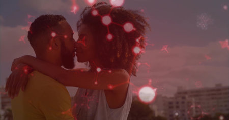 Leaning African American woman and man kissing on rooftop terrace, with metal railing and buildings. Romantic, intimacy, sunset, cityscape, silhouette, urban, connectionの写真素材