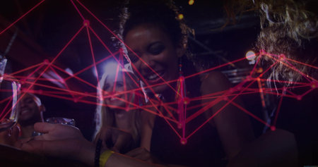 Laughing friends leaning at wooden bar under dim lights, holding drink glasses with red LED overlay. Socializing, nightlife, beverage, celebration, ambiance, modern, vibrantの写真素材