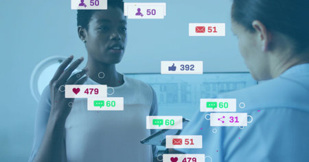 Woman in white sleeveless top gesturing in cool blue studio, with tablet and social metrics. Presentation, collaboration, demonstration, monitor, office, technology, dataの写真素材