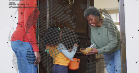 Holding wooden bowl senior in green sweater leaning at doorway, child holding orange pumpkin bucket....