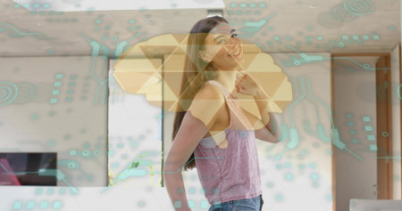 Smiling woman wearing pink top, blue jeans standing in living room, with TV and AR overlays. Honeycomb, hexagon, circuits, augmented, screen, interior, contemporaryの写真素材