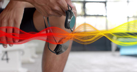Tightening swimmer holding mirrored goggles strap in dark briefs poolside. Athlete, pool, eyegear, backlit, vibrant, training, focusの写真素材