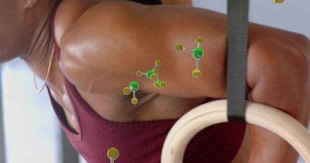 Training woman doing wooden ring exercise at gym in maroon sports bra, green-yellow overlays....