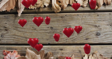 Floating glossy red hearts drifting on wooden deck, showing knots and seam gaps, dry-curled leaves....