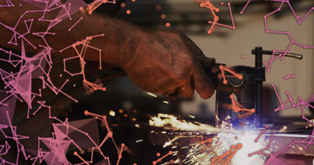 Grinding man gripping grinder at shop, cutting metal in vise sparking, long sleeves, pink overlay....