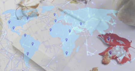 Showing translucent map across desk, displaying network lines, purple pins, notepad, red leaf, nut....