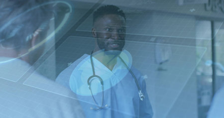 Consulting clinician in blue scrubs with stethoscope in clinic hall, white coat beside digital UI. Collaboration, supervision, hospital, corridor, interface, holographic, professionalの写真素材