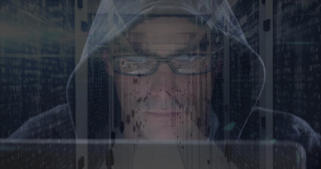 Typing man wearing dark hoodie and glasses in data center with laptop, server racks, code overlays....