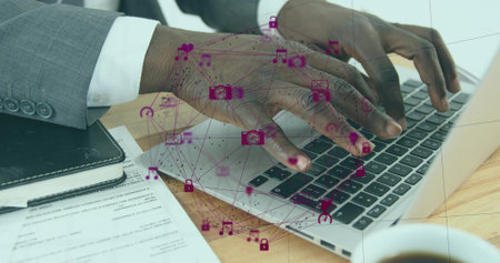 Typing hands in grey suit cuff working on silver laptop at office desk, magenta network overlay. Keyboard, notebook, documents, professional, digital, productivity, daylightの写真素材