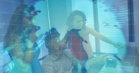 Collaborating office team discussing monitor at desk, sleeveless blue dress and light blazer, globe. Collaboration, global, map, analytics, data, professionals, workspaceの写真素材