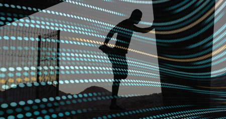 Stretching man in sportswear pulling foot beside pillar, turquoise dots over dunes and left gate. Silhouette, athlete, sunrise, horizon, desert, column, concreteの写真素材