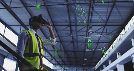 Inspecting engineer wearing hi-vis vest, tie, using VR headset with holo UI in hangar, copy space. Goggles, technician, futuristic, industrial, warehouse, training, workplaceの写真素材