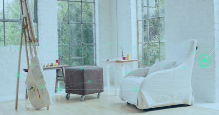 Sitting white slipcovered armchair offering cozy seating in bright art corner, with paint jars....
