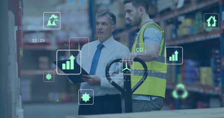 Checking manager white-shirt tie using tablet, operator hi-vis-vest moving pallet-jack in aisle, AR....