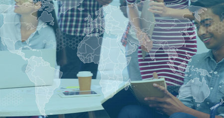 Discussing, man seated-right holding notebook+pen in blue shirt at round-table, hex-map, copy space....