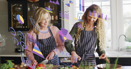 Preparing two women in dark aprons chopping produce in bright kitchen with chef knife and holograms. Mother, daughter, home, cooking, vegetables, herbs, islandの写真素材