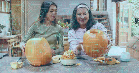 Preparing mother-daughter pair carving pumpkins on kitchen island, in green top and striped sweater....