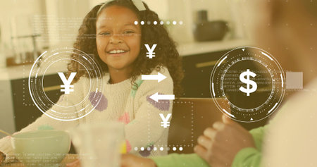 Smiling child wearing cream pom-pom sweater sitting at kitchen table with mugs. Family, girl, cozy, warm, home, lifestyleの写真素材