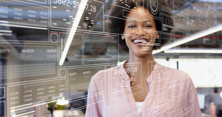 Smiling adult woman standing in tech office wearing pink blouse and white top with glass HUD....