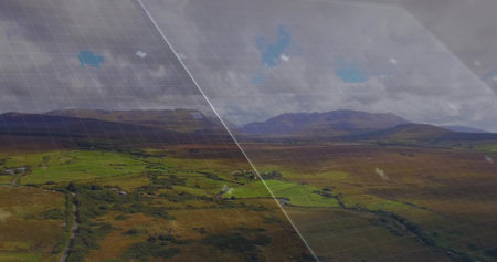 Showing aerial valley stretching across patchwork fields, hedges, winding road, farms, grid, glare....
