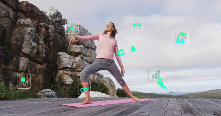Practicing woman pink top gray leggings holding pose on deck with pink mat. Yoga, outdoor, platform, cliffside, seascape, horizon, natureの写真素材
