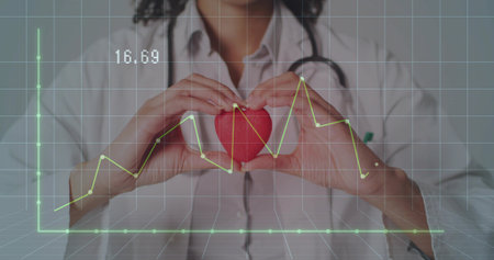 Holding red heart model, mid-adult female clinician showing stethoscope and ECG overlay at clinic. Cardiology, healthcare, doctor, clinical, digitalhealth, analytics, visualizationの写真素材
