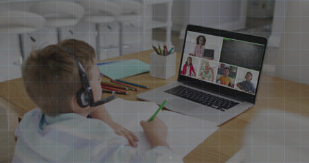 Writing child wearing headset, light top sitting at study corner, with laptop and green pencil. Remote, learning, student, virtual, instructor, education, technologyの写真素材