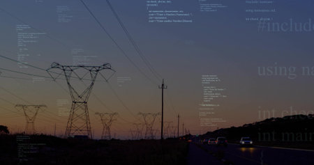 Silhouetting steel lattice tower beside two-lane road at dusk, with power lines, wooden pole, cars....