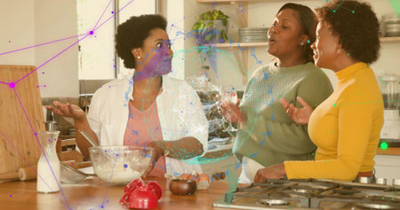 Preparing three women wearing light green and yellow tops mixing flour in home kitchen with bowl. Baking, cooking, friendship, teamwork, island, utensils, sunlitの写真素材