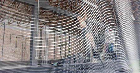 Preparing female trainee in athletic wear lifting barbell near rig at warehouse gym, white stripe. Industrial, training, weights, suspension, athlete, brick, spaciousの写真素材