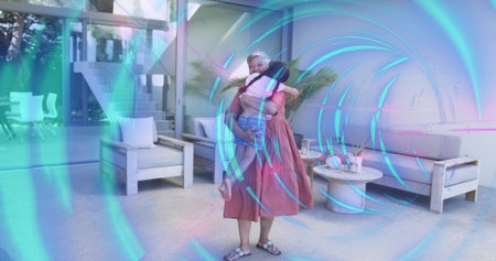 Holding mature woman supporting child in modern lounge, reddish-pink dress, spiral effect. Parent, kid, bond, warmth, home, furniture, glassの写真素材