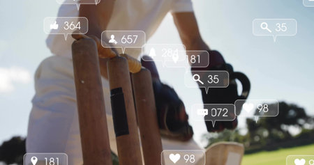 Reaching cricketer in white uniform touching stumps with glove on grassy pitch, overlay. Cricket, wicket, bat, field, outdoor, sunny, grassの写真素材